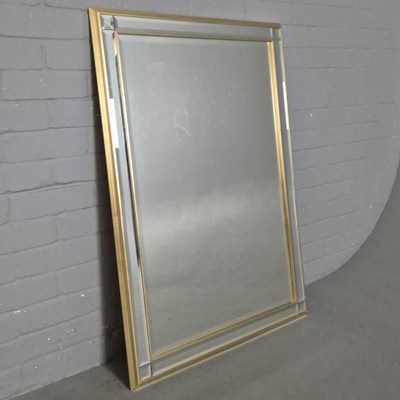 Lot 717 - WALL MIRROR WITH A GILT FRAME AND BEVELLED MIRRORED BORDER